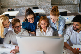 six coworkers gathered around computer